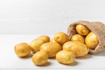 Young potatoes. Fresh potatoes  on a wooden background.Harvesting collection. organic, freshly dug potatoes. Agricultural background. Vegan. Vegetables.Place for text.Copy space