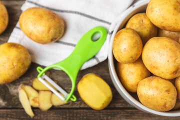 Young potatoes. Raw potatoes and knife on a wooden background.Peel potatoes.Harvesting collection. organic, freshly dug potatoes. Agricultural background. Vegan. Vegetables.Place for text.Copy space