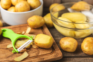 Young potatoes. Raw potatoes and knife on a wooden background.Peel potatoes.Harvesting collection. organic, freshly dug potatoes. Agricultural background. Vegan. Vegetables.Place for text.Copy space