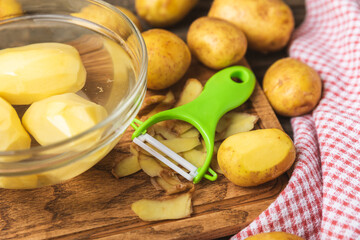 Young potatoes. Raw potatoes and knife on a wooden background.Peel potatoes.Harvesting collection. organic, freshly dug potatoes. Agricultural background. Vegan. Vegetables.Place for text.Copy space