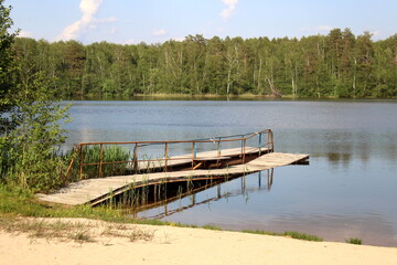 Fototapeta premium There is a small bridge on the lake for swimming in summer.