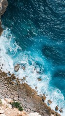 Aerial view of lone person by the turquoise coastal waves