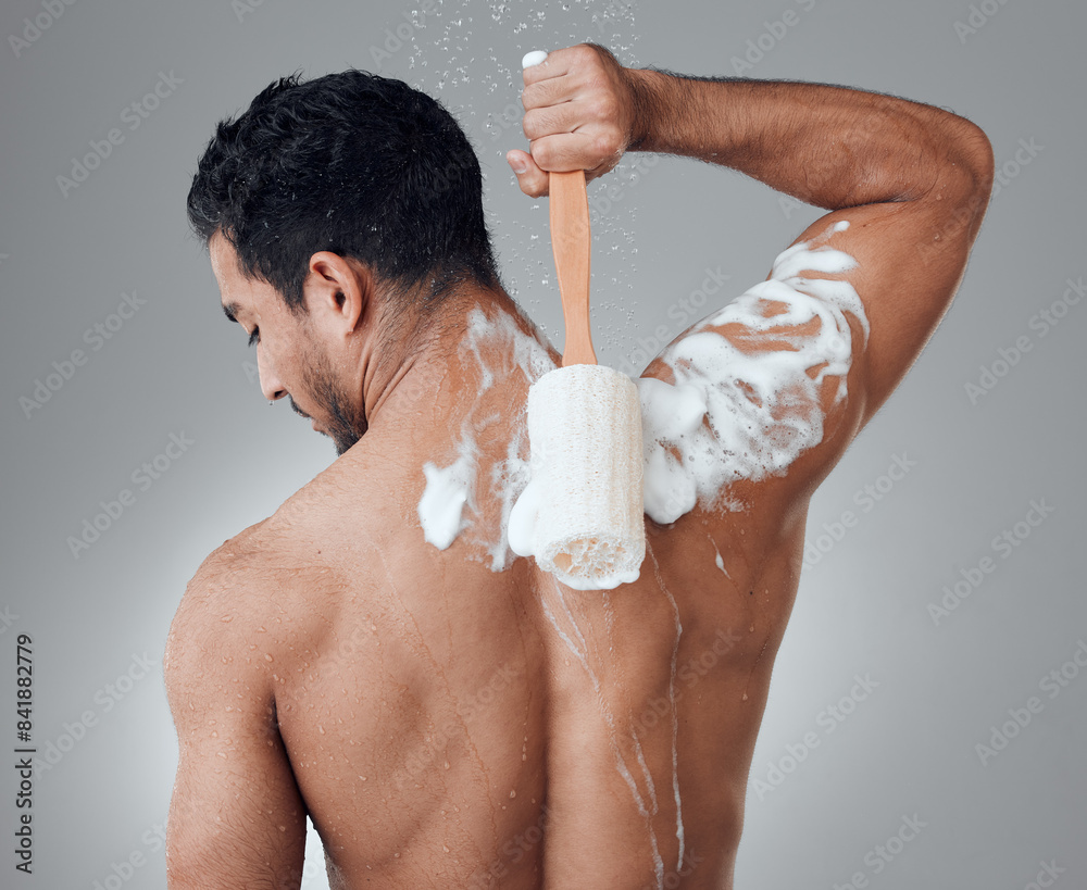 Poster Man, shower and loofah for washing in studio, foam and cleaning or grooming on gray background. Male person, cosmetics and sponge for exfoliate treatment or back soap, skincare and hygiene or beauty