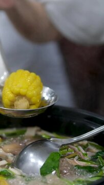 corn soup Traditional Dominican creole food called Sancocho Corn soup. Eating Traditional Mexican food, tex mex cuisine. Hands taking cooked quesadilla from wooden tray, nacho
