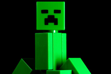 Naklejka premium LEGO Minecraft green Creeper Mob on the black background