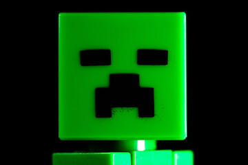 Naklejka premium Face of LEGO Minecraft green Creeper Mob on the black background