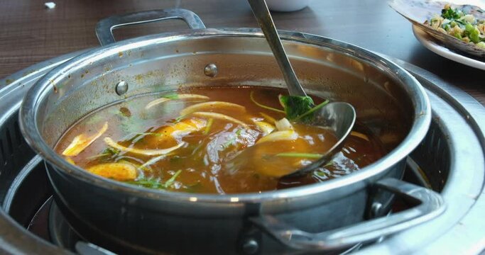 broth with vegetables Stirred ladle chicken with noodles and potatoes cold soup in a small saucepan on the gas stove near the window