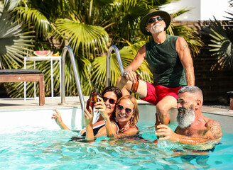 Senior friends enjoying a pool party with drinks