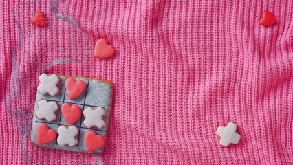Noughts and crosses. Horizontal Banner for Website. Love Conception. Gingerbread on a Pink Sweater Background. Valentines Day Wallpaper