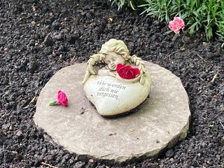 Engel mit Herz und Blumen auf dem Friedhof im Inschrift