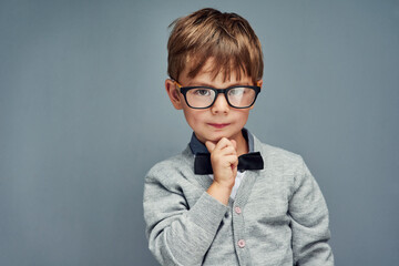 Fashion, glasses and portrait of clever boy in studio isolated on blue background for intelligence....
