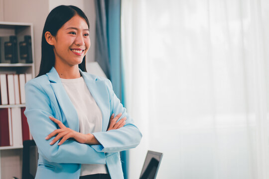 Beautiful Asian business woman uses digital tablet and laptop to do remote work at the office, online seminar or video call. - Powered by Adobe
