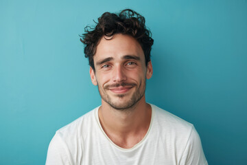 A close up portrait of a young man with a subtle smile