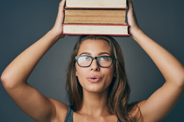 Woman, head and balance books in studio for learning, education or studying isolated on background....