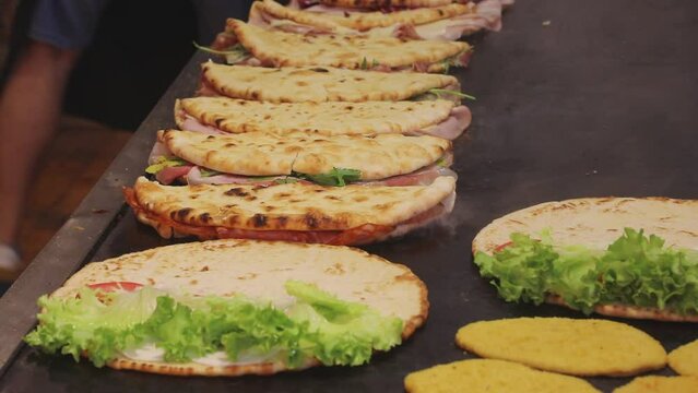 Italian flatbread called Piadina Romagnola or Spianata Bolognese being cooked on a very hot griddle