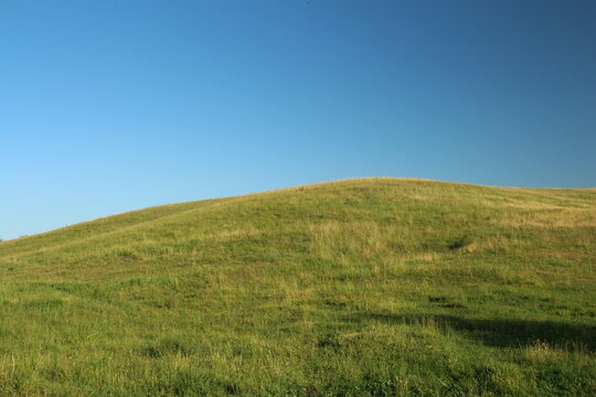 A grassy hill with blue sky