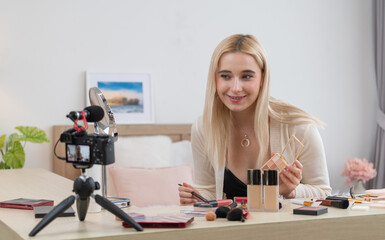 Young woman making beauty and cosmetic tutorial video content for social media. Beauty blogger...