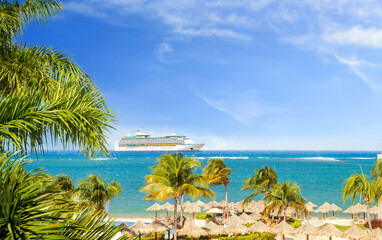 View from tropical beach on cruise ship sailing from port 