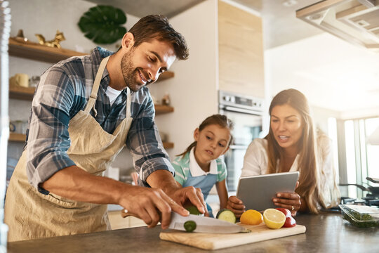 Family, cooking and diet with people, tablet and online for recipe or ingredients on kitchen counter for dinner. Healthy, food and meal prep for nutrition, together or bonding in clean eating at home