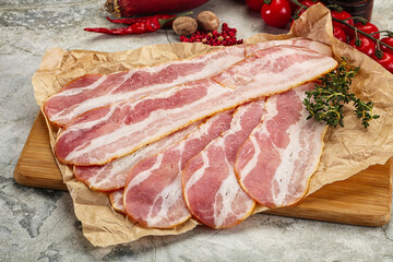Sliced pork bacon over board
