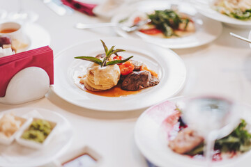 food on a white tablecloth. many different dishes arranged on the table view of the chef in a restaurant. 