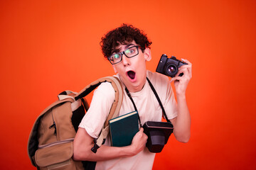 Vacations and holidays. Funny lost tourist with a backpack. Orange background.