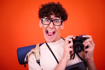 Vacations and holidays. Funny lost tourist with a backpack. Orange background.