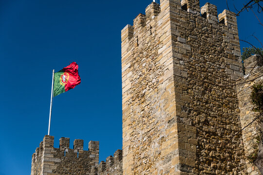 Flag of Portugal and Lisbon at S&atilde;o Jorge Castle. Exterior wall facade of historic ruin Saint George Castle