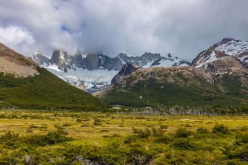 Patagonia mountains in El Chalten, Argentina. Monte Fitzroy and Cerro Torre summits granite walls above lake laguna Torre with icebergs floating ice and dark clouds nasty patagonian weather 