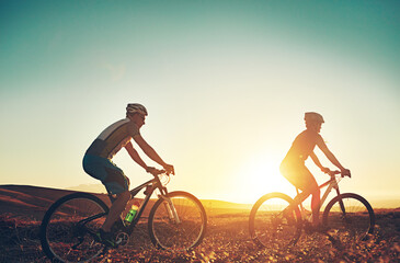 Sunset, sky and people on bicycle with adventure, race and exercise trail in nature together....