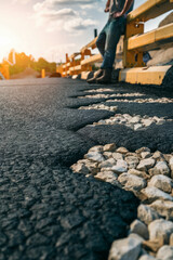 A close-up photograph of freshly paved asphalt, showcasing the textured surface and black, glossy finish. 