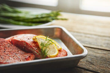 Tray, lemon and grilled salmon with asparagus for healthy, wellness and nutrition fine dining cuisine. Diet, meal and gourmet dish of fish, vegetables and citrus fruit for dinner on wooden table.