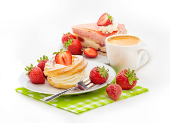 A piece of cake with strawberry souffle, custard cake with buttercream, fresh strawberries and a cup of coffee on a green napkin. Isolate on a white background