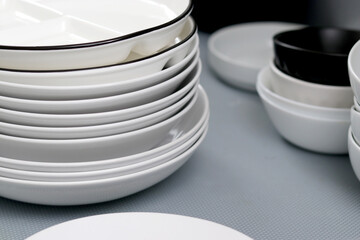 Close up of white plates and other dishes in a kitchen cabinet