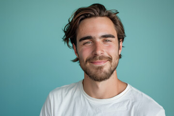 A close up portrait of a young man with a subtle smile