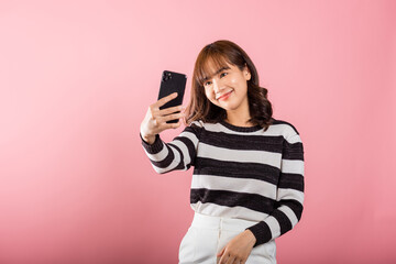Happy Asian portrait beautiful cute young woman smiling excited making selfie photo, video call on...