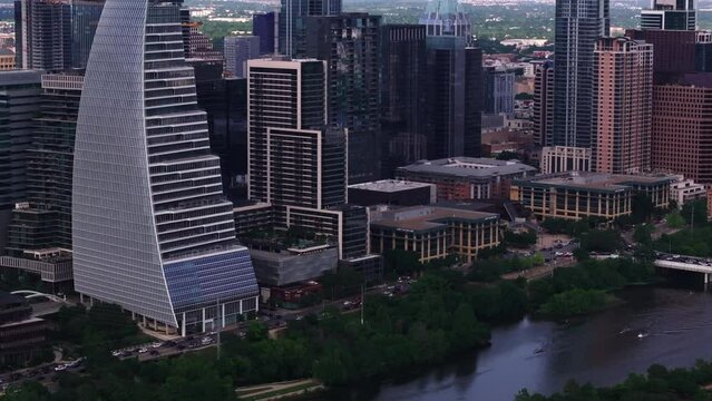 Aerial view of Austin's city skyline, featuring modern skyscrapers like Block 185 and tranquil water of Colorado river weaving through the urban landscape