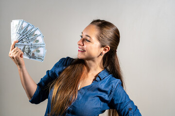 Mujer abanicandose con un montón de billetes en señal de abundancia y riqueza