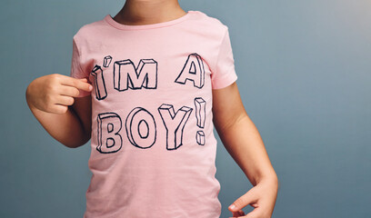 Hands, child and point at text on shirt for gender identity, style and fashion model by blue...