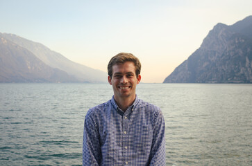 Man smiling in a summer sunset in the mountains and a lake