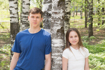 Obraz premium Portrait of a teenager of a girl and a boy in a park in spring on a sunny day