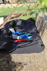 Laying an anti-weed mat in the garden together with paving stones and decorative pebbles