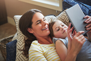 Tablet, mother and girl on sofa with internet for reading ebook, relationship love and streaming animation for fun in home. Child, mama and tech on couch with website for learning language and games