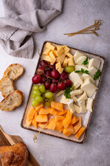 Cheese plate with different cheese, grapes and melon.