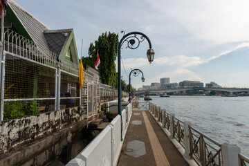 A pier in the river of Bangkok with light posts hanging from above in a romantic scenery