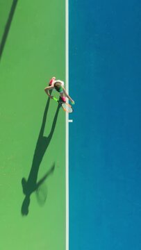 Vertical Screen: A tennis player demonstrates athleticism during an exhilarating match on a blue court, showcasing dynamic movement and skilled play while embodying vigor and sportsmanship
