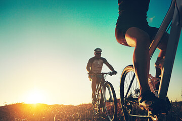Sunrise, people and friends on bicycle with adventure, race and exercise trail in nature together....