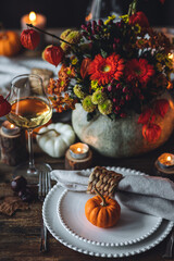 Beautiful seasonal decorated Thanksgiving table for cozy family dinner or fall luxury countryside wedding. Elegant beautiful setting for holiday event, party, reception. Wineglasses and fancy dishes.