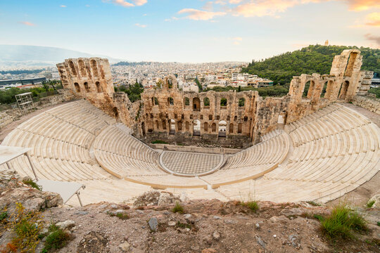 Full view from above of the Odeon of Herodes Atticus, the ancient amphitheater at the south base of Acropolis Hill, with the modern city of Athens, Greece in view behind.	