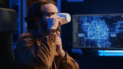 Computer scientist updating artificial intelligence neural networks, drinking coffee and writing...